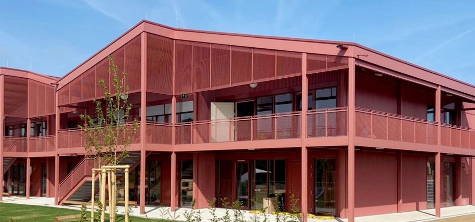 Farbig feuerverzinkte Kita-Fassade mit Gitterrosten in Edermünde