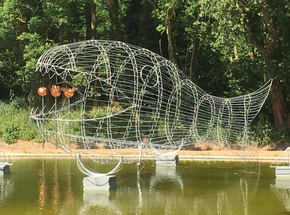 Große Fischskulptur aus feuerverzinktem Stahldraht mit filigranen Details im Skulpturenpark